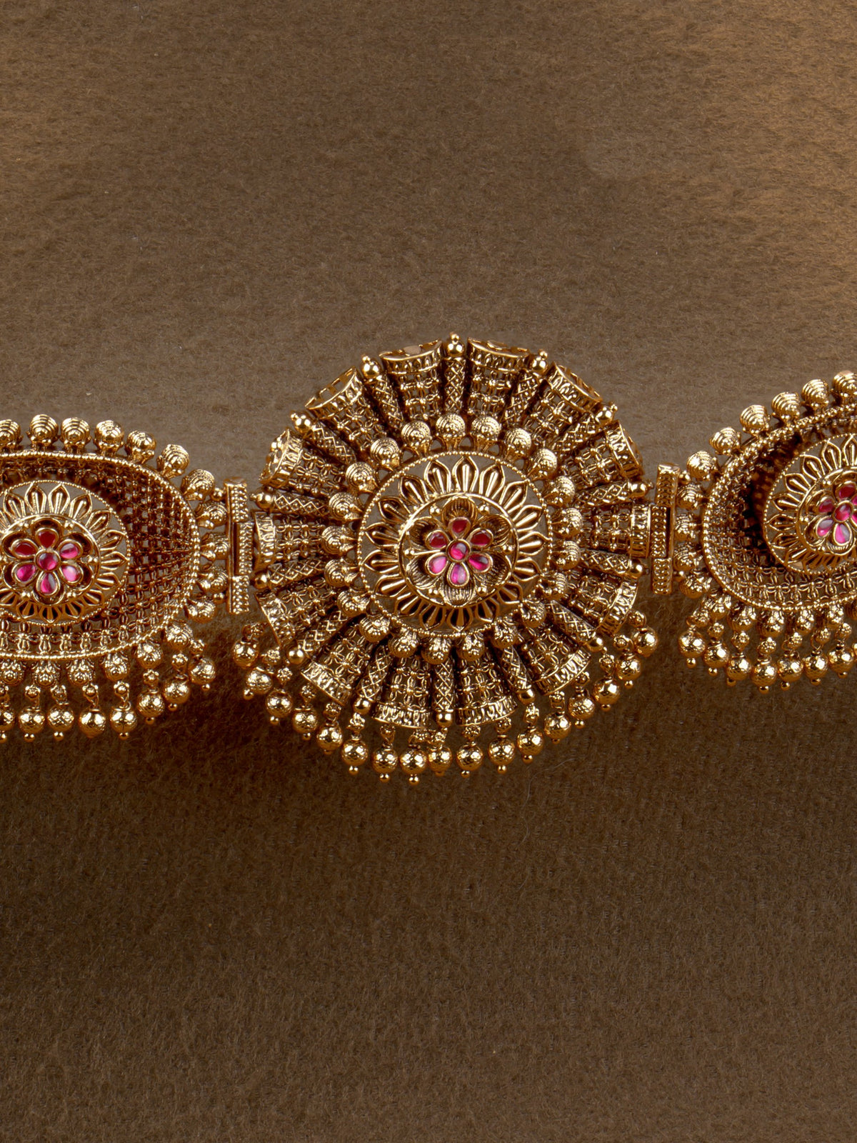 Suryakanthi Hip Belt - close-up of sunburst centrepiece and ruby flower medallions